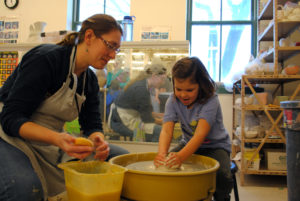 photo of woman and little girl playing with clay